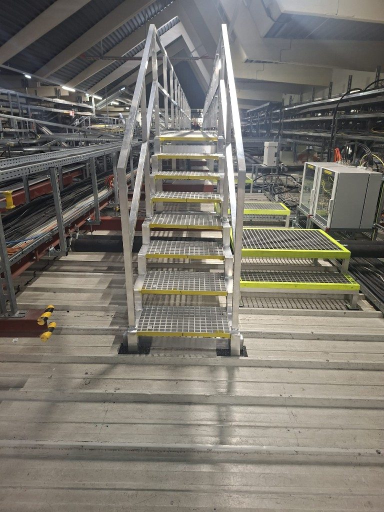 Stahltreppe mit Gitterroststufen in einer Industriehalle